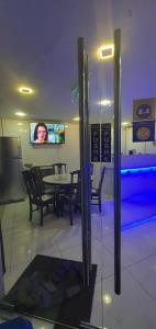 吉隆坡The 8 Capsule Hotel Bukit Bintang的一间带桌椅和电视的用餐室