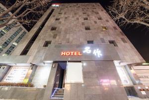 水原市HOTEL MYEONG JAK的酒店大楼前面有酒店标志