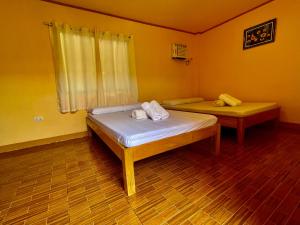 锡基霍尔GOLDEN SUNSET INN的一间设有两张床的卧室,位于拥有黄色墙壁的房间