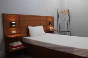 长滩岛Cerca Hotel的一间卧室配有一张大床和木制床头板
