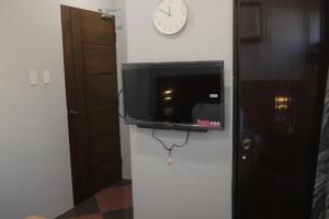 长滩岛Cerca Hotel的墙上的电视,墙上挂着时钟