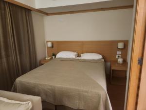 圣保罗La Bella Cintra, 672的一间卧室配有一张大床和一把椅子