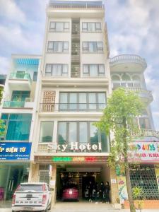 Uông BíSky hotel 390 QUang Trung Thành phố Uông Bí tỉnh Quảng Ninh的一座白色的大建筑,外面的人