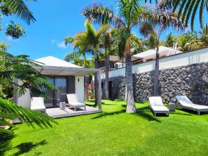 Saint BarthelemyVilla Coco Rock的房屋前的庭院,带椅子和棕榈树