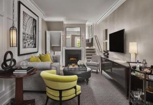华盛顿华盛顿瑰丽酒店的客厅配有沙发、椅子和电视