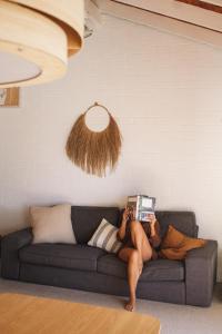 扬巴Pippi Beach Loft的躺在沙发上看书的人