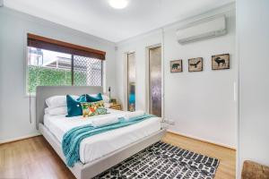 黄金海岸'Buzzing Surfers' Vibrant Indoor-outdoor Lifestyle的一间卧室设有一张床和一个窗口