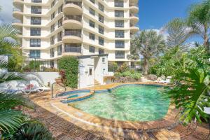 黄金海岸Seaview Inn - Pure Palm Beach Resort style Bliss的一座大建筑前的游泳池