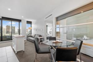 墨尔本Resort Style Living Yarra Wharf的一间卧室和一间带一张床铺和一张桌子的客厅