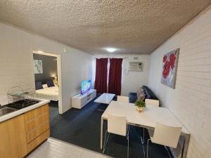 珀斯珀斯城市公寓酒店 的厨房以及带桌椅的起居室。