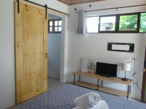 Santiago EsteAirport Green Studio的一间卧室设有木门、一张床和一张书桌