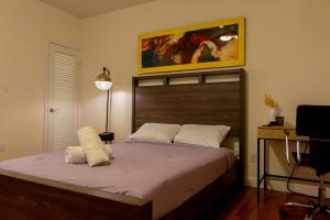 劳德代尔堡Las Olas Studio - 5 minutes from Las Olas Beach的一间卧室配有一张大床和木制床头板