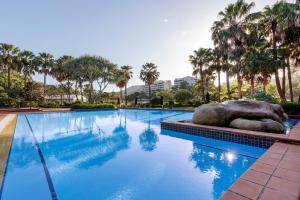 科夫斯港Club Wyndham Coffs Harbour Terraces的一座拥有大岩石和棕榈树的游泳池