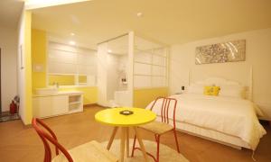 IksanIksan 4 Seasons Hotel的一间卧室配有一张床和一张黄色的桌子及椅子