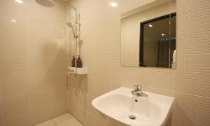 IksanIksan 4 Seasons Hotel的浴室配有盥洗盆和带镜子的淋浴