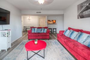 休斯顿Spacious 3BR, 2BA Condo near Medcenter & NRG的客厅配有红色沙发和红色桌子