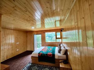 拉冲Apple Valley Cottages Lachung的卧室配有木墙内的一张床