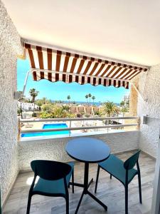 美洲海滩Borinquen Vista Mar的阳台配有桌椅,享有泳池美景