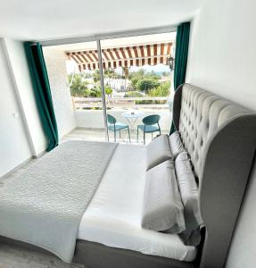 美洲海滩Borinquen Vista Mar的一间卧室配有一张床,阳台配有桌子