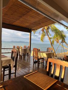 湄南海滩Adarin Beach Resort的海滩上带桌椅的餐厅