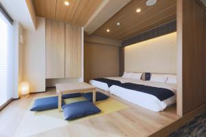 东京stayme THE HOTEL Asakusa Riverside的一间卧室配有一张大床和一张桌子