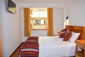 皮萨克Hotel Inka Pisac的一间卧室设有一张床和一个窗口