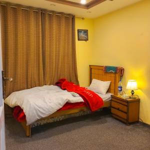 锡卡都Ringchan Guest House & Restaurant的一间卧室配有一张床铺,床上铺有红色毯子