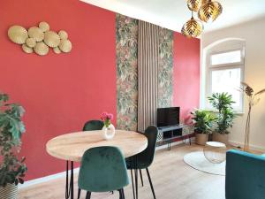 德累斯顿tealounge 2 Raum + Küche的配有桌椅和红色墙壁的房间