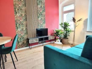 德累斯顿tealounge 2 Raum + Küche的客厅配有蓝色的沙发和电视