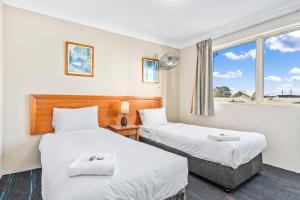 悉尼APX帕拉马塔公寓式酒店的带窗户的客房内的两张床