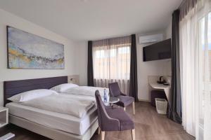 阿斯科纳卢纳加尔尼酒店的酒店客房带一张床、一张桌子和椅子