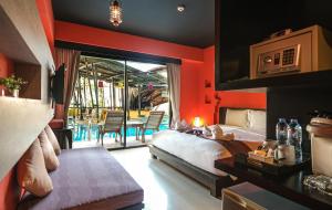 查汶Bhundhari Chaweng Beach Resort Koh Samui - SHA Plus的卧室配有一张床和一张桌子及椅子