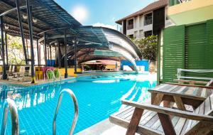查汶Bhundhari Chaweng Beach Resort Koh Samui - SHA Plus的一个带长凳的游泳池和一座建筑