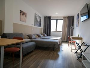 马德里Alianza Suites的一间带两张床和一张沙发的客厅