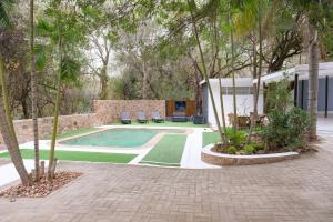 侯斯普瑞特Kadima Safari Lodge的一座树木繁茂的庭院内的游泳池