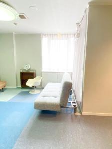 福山ROSE ROOM的带沙发和窗户的客厅