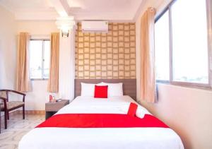 胡志明市Tan Hoang Long Hotel的一间卧室配有一张带红色毯子的床