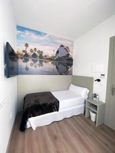 瓦伦西亚Hotel BESTPRICE Valencia的卧室配有一张床,墙上挂有绘画作品