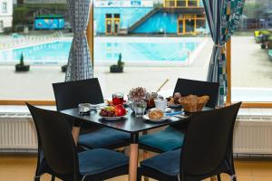德辛Aqua Hotel的一张桌子,上面有食物,享有游泳池的景色