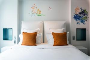 巴黎1K Paris的卧室配有带橙色枕头的白色床