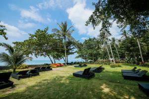 瑶亚岛Blue Bay Resort的海滩附近的草地上坐着一排黑椅子