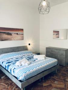 斯波托尔诺Casa Emma 400 mt dal mare的一间卧室配有一张带蓝白色床单的大床