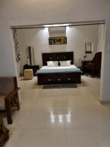 贾巴尔普尔Leela Homestay Jabalpur - Lily - 2 BHK Luxury appartment的一间卧室配有一张床、一张沙发和一把椅子