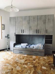 斯波托尔诺Casa Emma 400 mt dal mare的一间卧室设有一张大床,铺有木地板