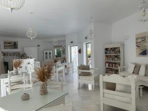 安迪帕罗斯岛阿特米斯酒店的白色的客厅配有白色的椅子和桌子