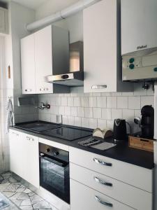 斯波托尔诺Casa Emma 400 mt dal mare的厨房配有白色橱柜和炉灶烤箱。