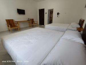 瓜拉丁加奴ASM Roomstay-4-2 Queen Beds的客房设有两张床、一张桌子和电视。