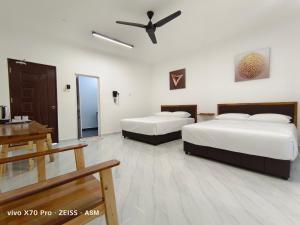瓜拉丁加奴ASM Roomstay-4-2 Queen Beds的酒店客房配有两张床和吊扇。