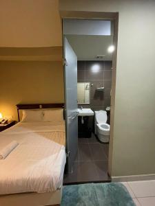 吉隆坡Al Amin Muslim Friendly Hotel的一间卧室配有一张床,浴室设有卫生间
