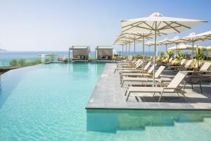 ElaiokhórionAnasa Luxury Resort的一个带躺椅和遮阳伞的游泳池